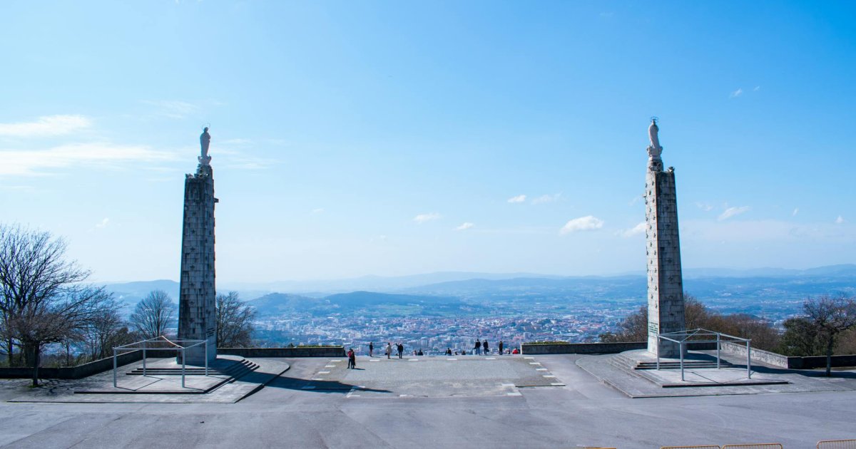 Escadaria barroca do Bom Jesus do Monte em Braga, com fontes alegóricas e vegetação verdejante ao pôr do sol