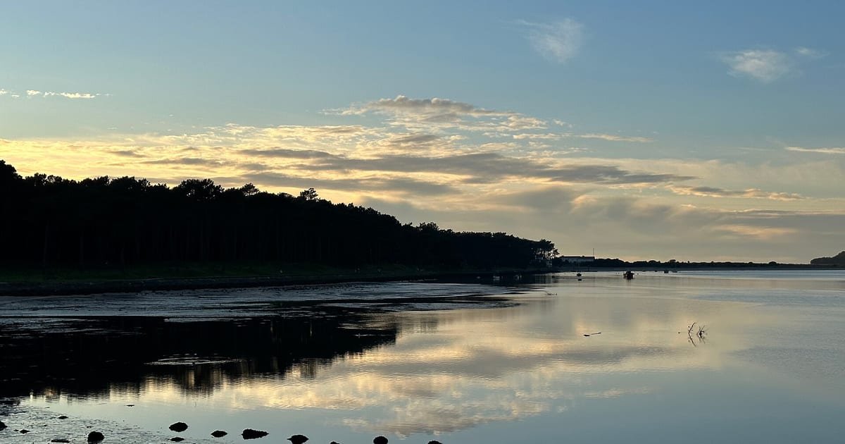 Pôr do sol dourado sobre o estuário do rio Minho ao entardecer, em Caminha, Viana do Castelo, cenário romântico do Norte de Portugal
