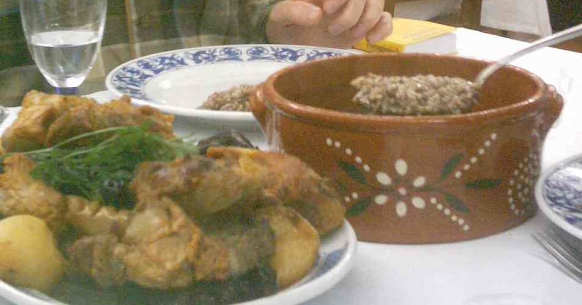 Prato de rojões à moda do Minho acompanhados com arroz de sarrabulho, especialidade tradicional da gastronomia minhota