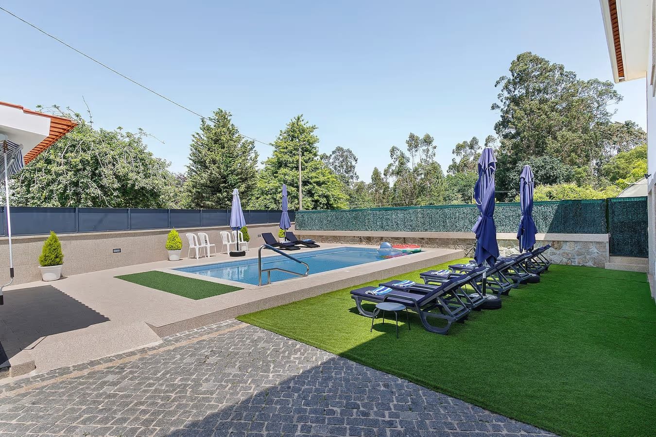 Piscina privada exterior com espreguiçadeiras e relvado do Alojamento Rio Neiva, em Tregosa, Barcelos, no Minho.